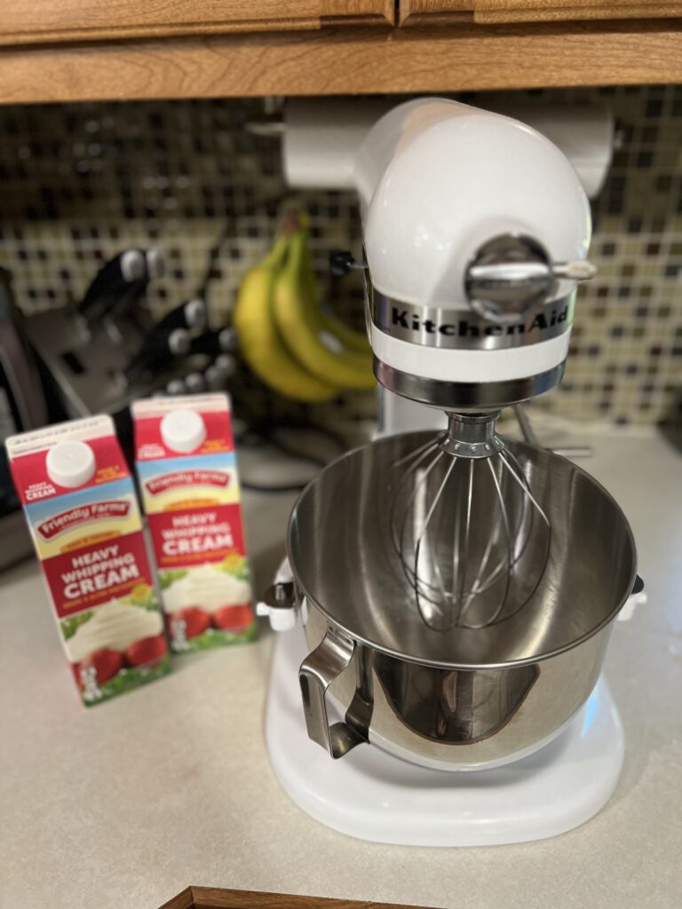 stand up mixer on the counter next to heavy whipping cream