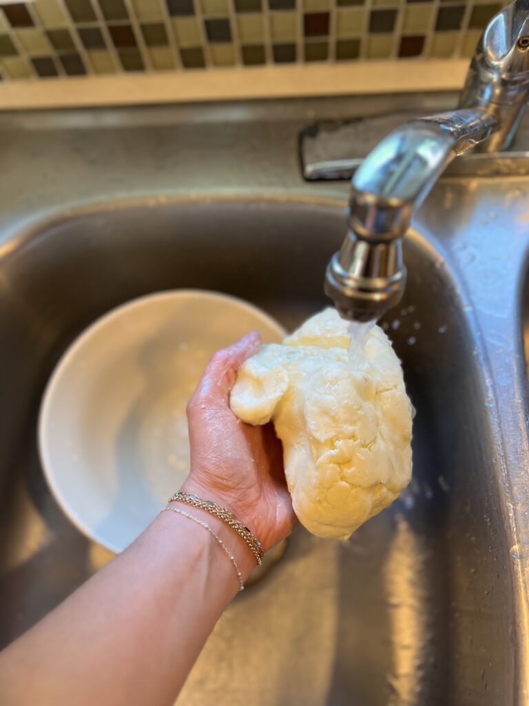 girl rinsing homemade butter in the sink