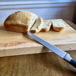 loaf of sourdough sandwich bread resting on a cutting board