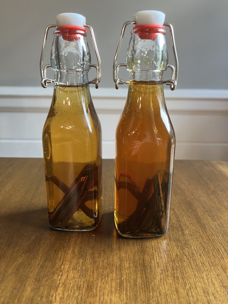 Homemade vanilla extract in clear glass bottles.