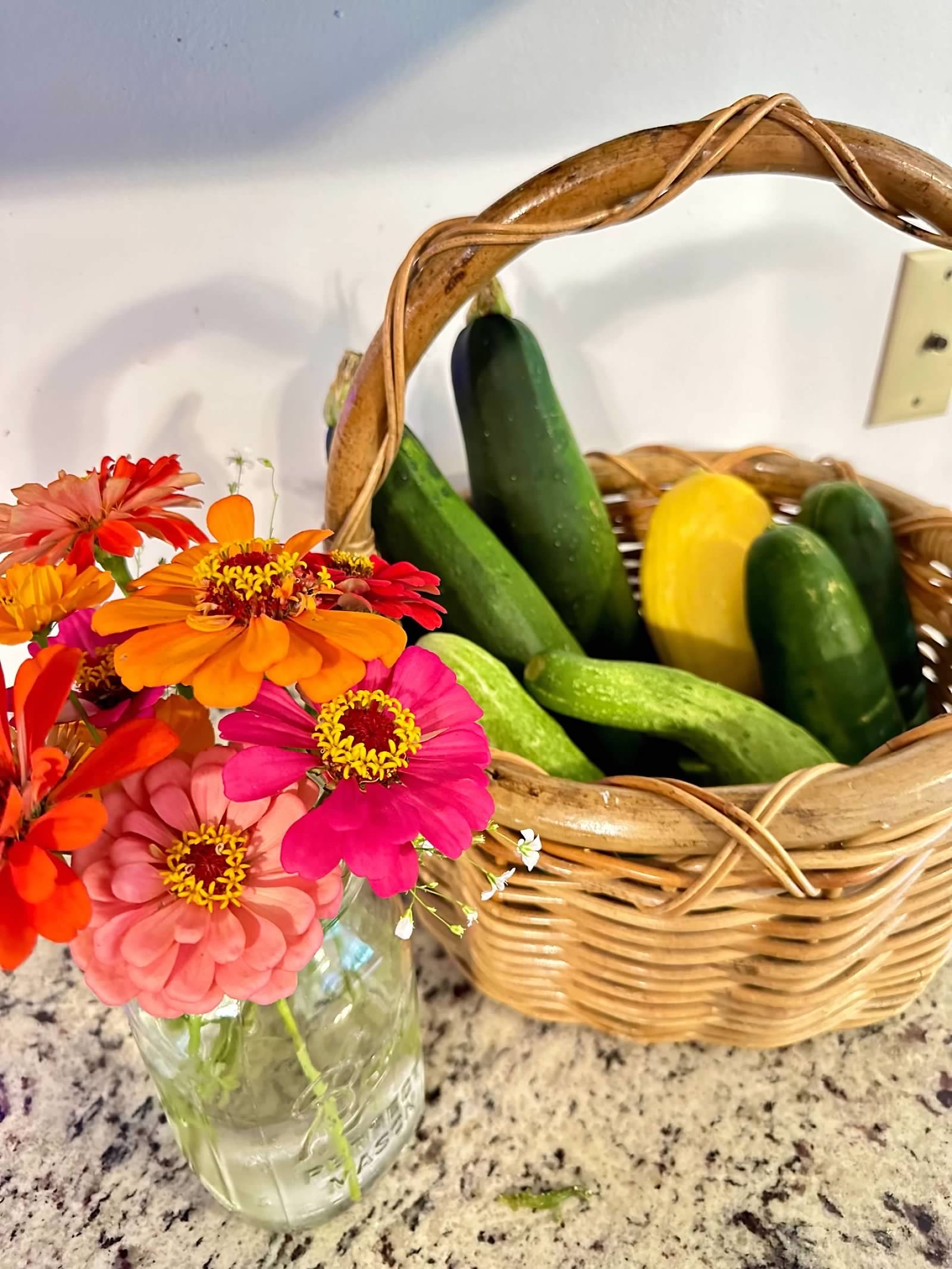 Zinnia flowers sitting on the counter next to veggies