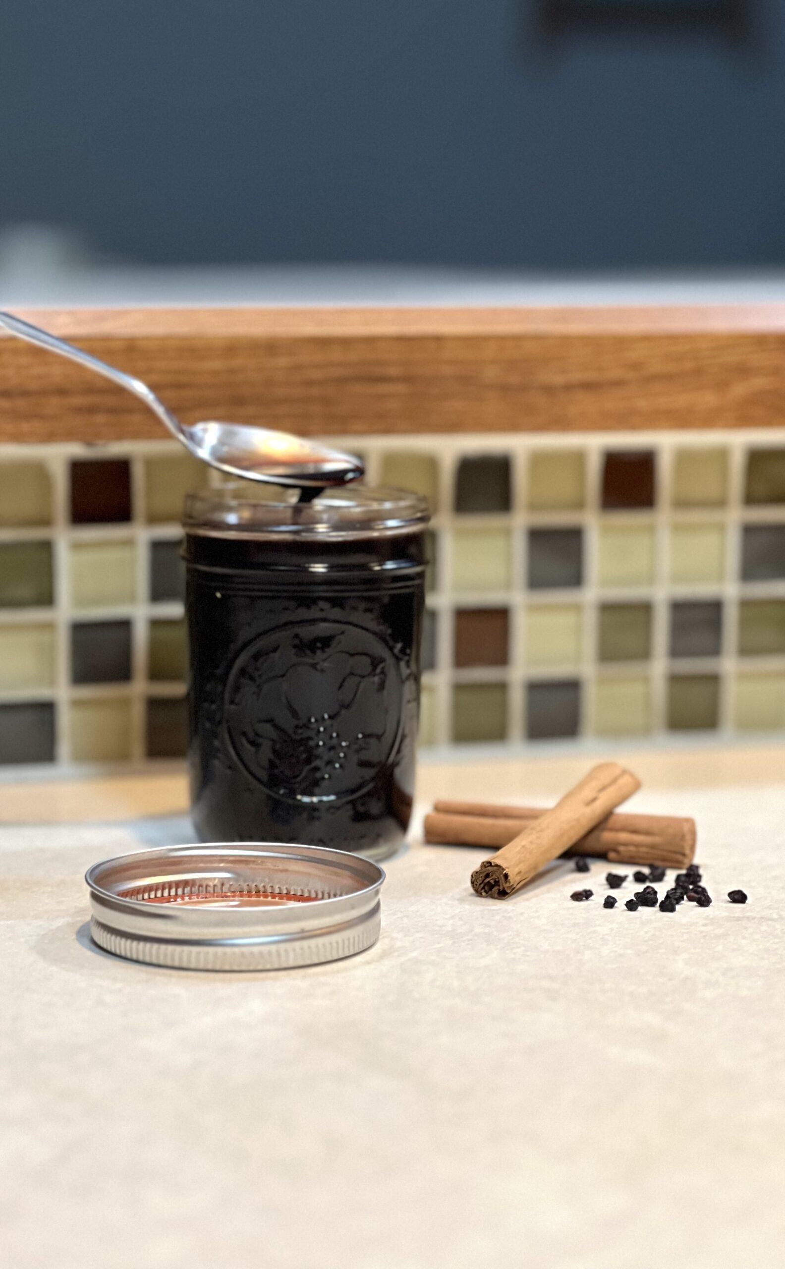 The best homemade elderberry syrup with spoon sitting on the counter